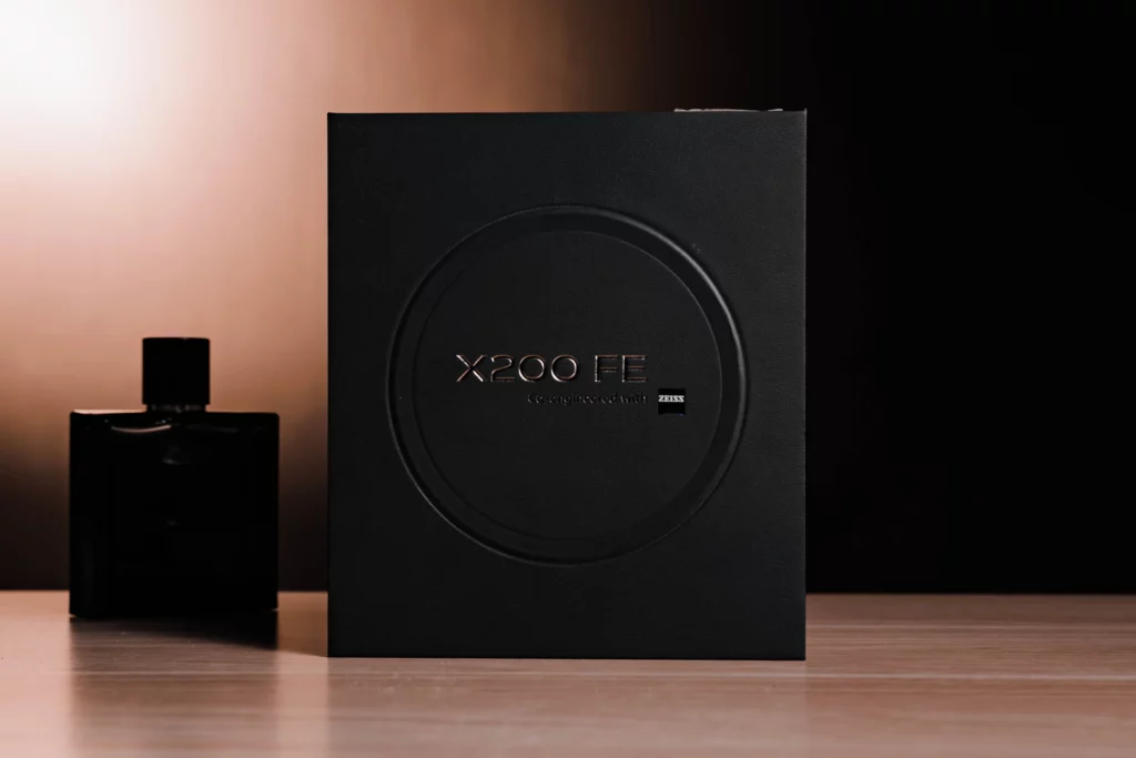 Black box with "X200 FE" next to a dark perfume bottle.