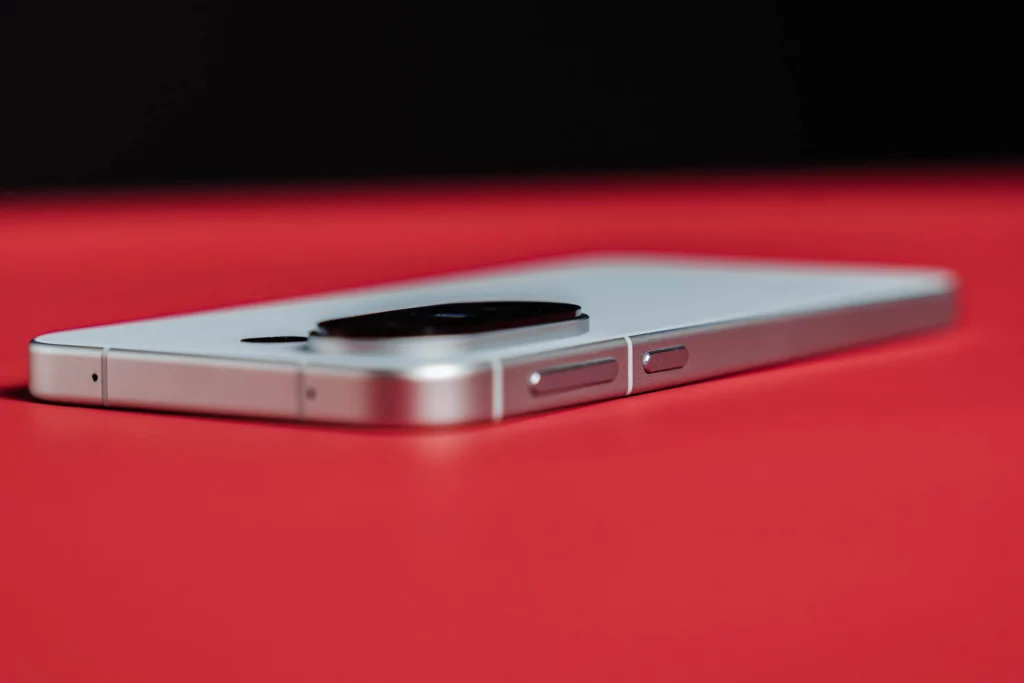 Side view of a white smartphone showing buttons and camera bump.