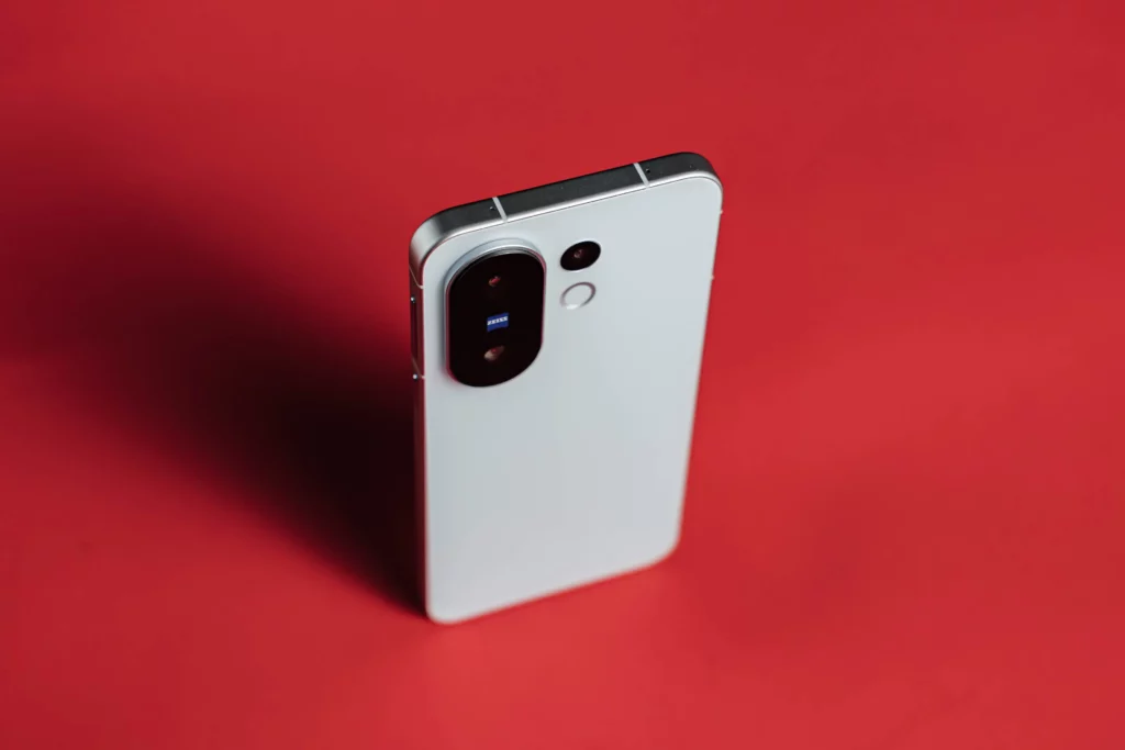 White smartphone with prominent camera module on a red background.