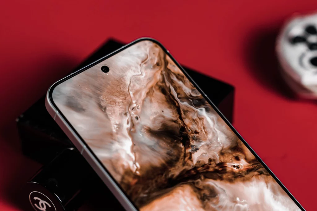 Close-up of smartphone screen with intricate brown and white abstract wallpaper.