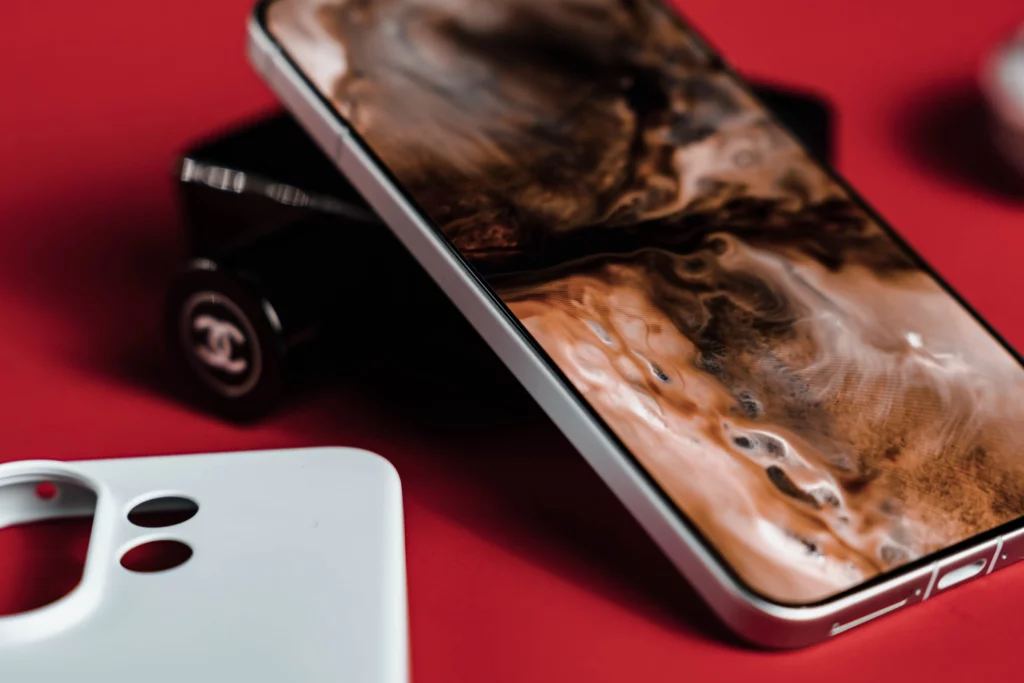 Angled view of smartphone with abstract brown wallpaper and a white case.