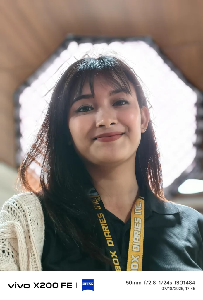 Woman smiling at the camera, wearing an "Unbox Diaries" lanyard.