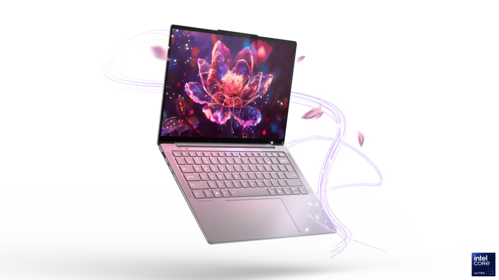 A floating Lenovo Yoga Slim 7i Aura Edition laptop in a rose gold or silver finish, with its screen displaying a vibrant floral graphic and subtle glowing particles around it, highlighting its sleek design.