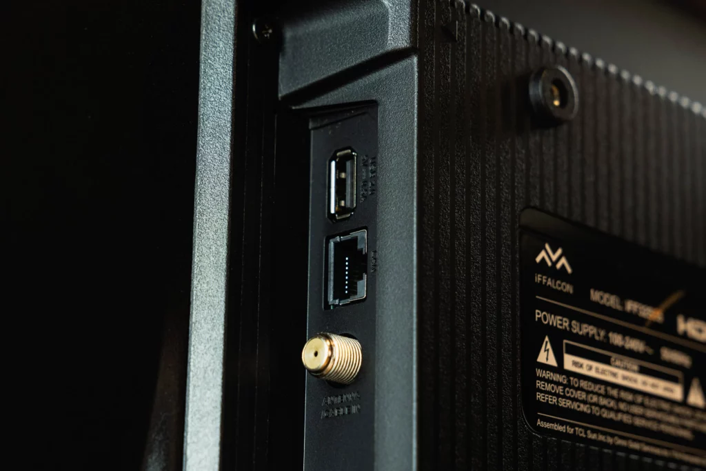 Close-up of the back of a black television showing a cluster of ports. From top to bottom, there are two USB ports, an Ethernet port, and a coaxial cable input.