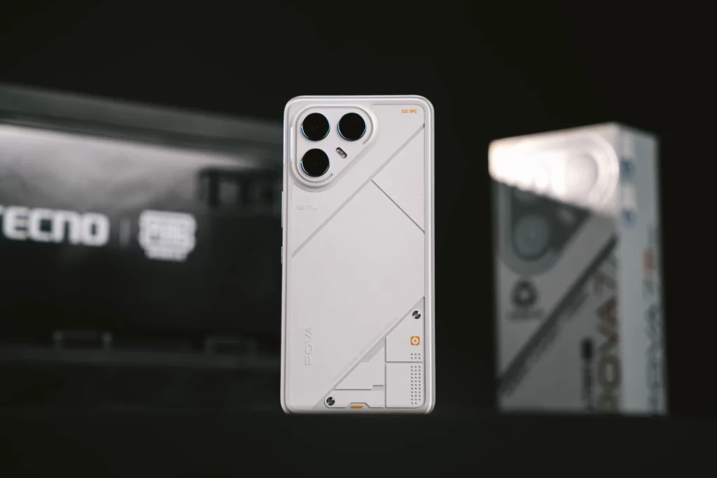 The Tecno POVA 7 Ultra 5G smartphone is showcased from the back, highlighting its white, geometric design and triple camera system, with the product box visible in the background.