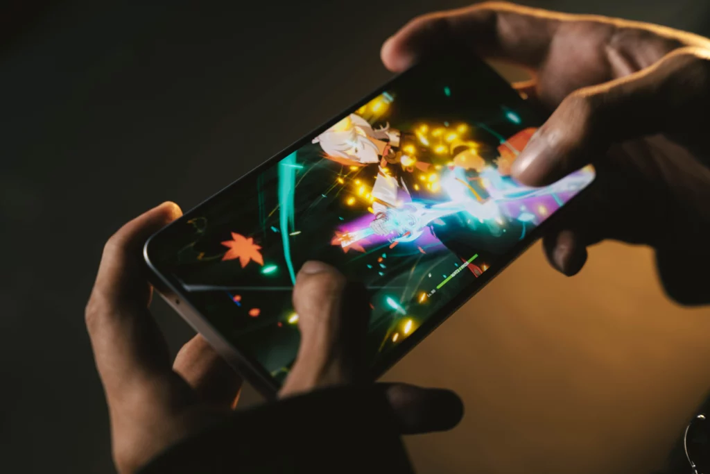 A person's hands playing a fast-paced action game on the Tecno POVA 7 Ultra 5G, with bright in-game effects and character abilities visible on the screen.