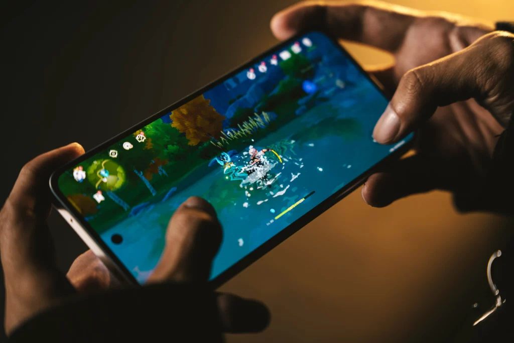 Hands holding the TECNO POVA 6 Pro 5G while playing a mobile game on the bright, colorful screen, highlighting the immersive gaming experience.