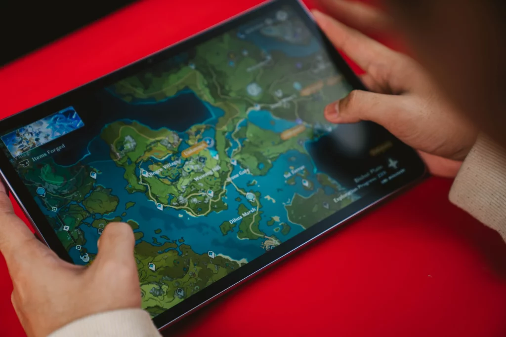 A person's hands holding the HUAWEI MatePad 11.5 horizontally and playing a video game, with a detailed map and interface visible on the screen.