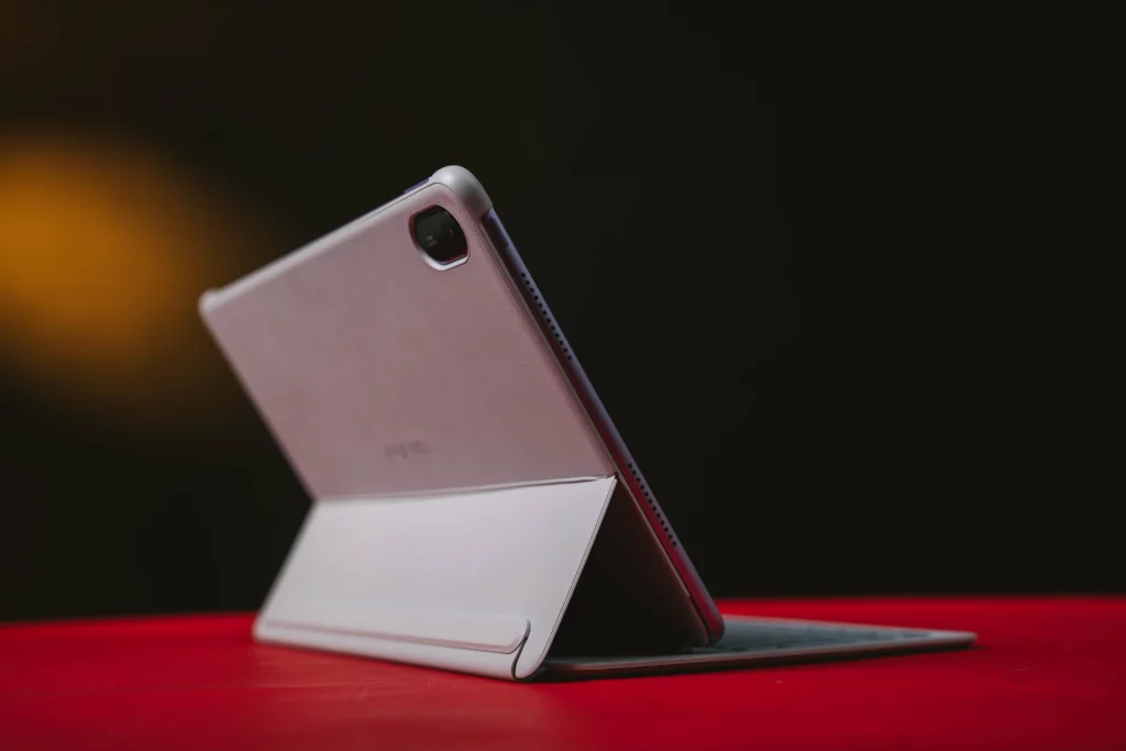 The purple HUAWEI MatePad 11.5 tablet with a protective cover propped up on a red surface, showcasing the back of the device and the camera module.