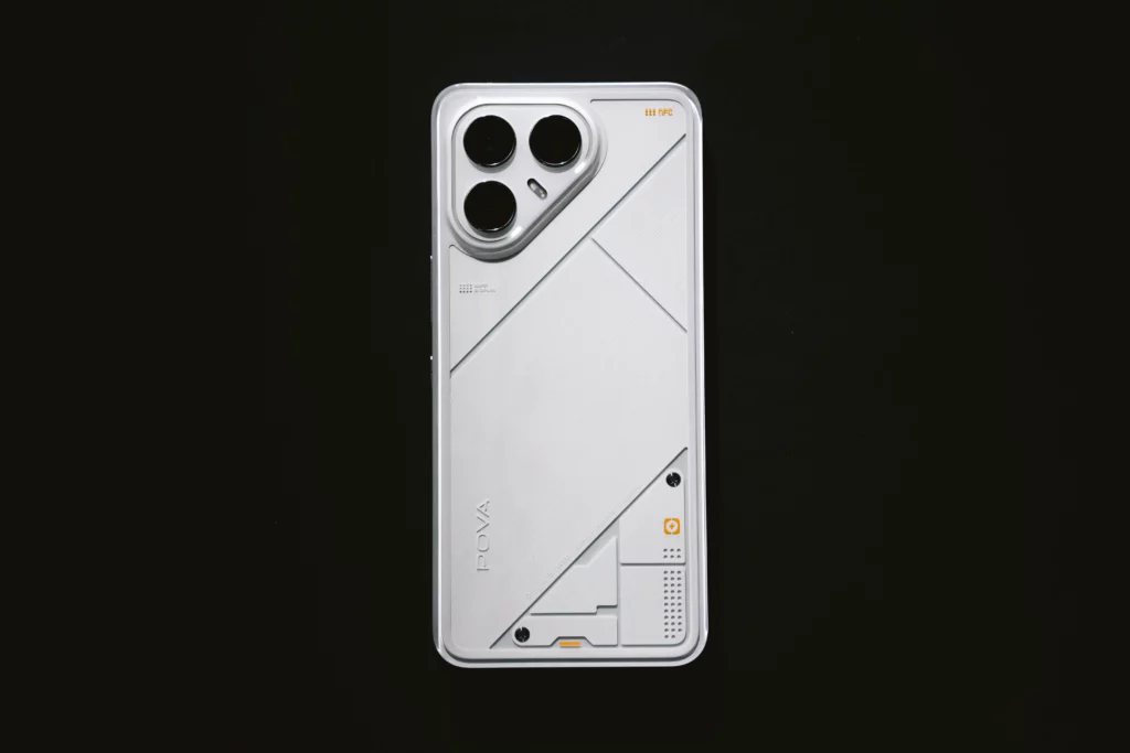 A product shot of the white TECNO POVA 7 Ultra 5G smartphone, showing the back of the device. The phone has a futuristic, angular design with subtle geometric patterns and a triple-camera module in the top left corner.