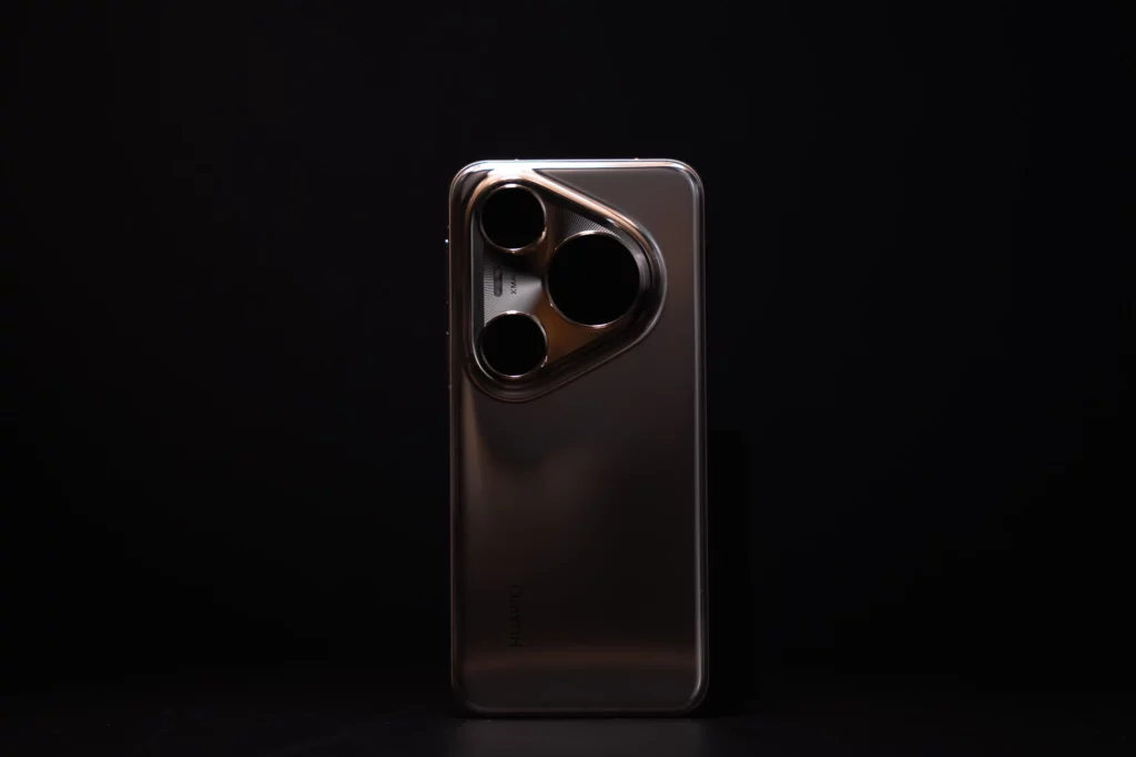 A silver HUAWEI Pura80 Ultra smartphone standing upright on a dark surface against a black background, with its prominent three-lens camera module and the "HUAWEI" logo visible.