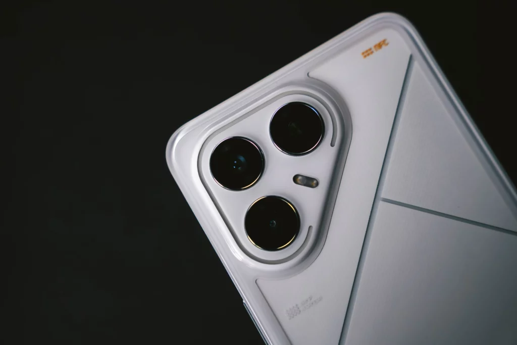 A close-up, angled shot of the top-left corner of the white TECNO POVA 7 Ultra 5G. The focus is on the phone's triple-camera module and the futuristic, clean design on the back.