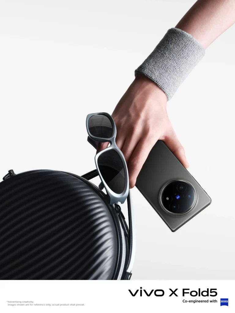 A hand holding the closed vivo X Fold5 smartphone, displaying its large circular camera module. The image shows the phone's sleek design next to a pair of sunglasses and a backpack, emphasizing its portable and stylish nature. The text 'vivo X Fold5' and 'Co-engineered with ZEISS' are at the bottom.