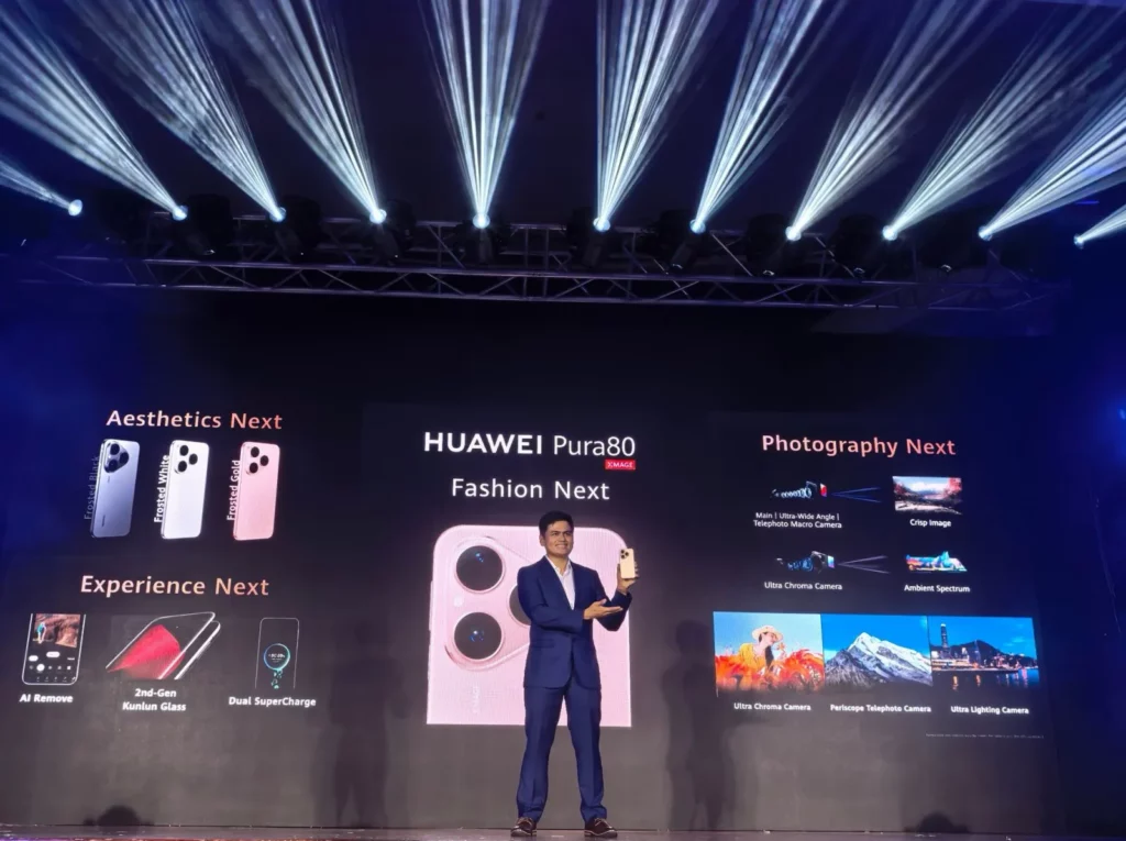 A HUAWEI product expert on a brightly lit stage holding up the HUAWEI Pura 80 smartphone. Behind him, a large screen displays key features of the phone, including its design, camera capabilities, and technology like AI Remove and Dual SuperCharge.