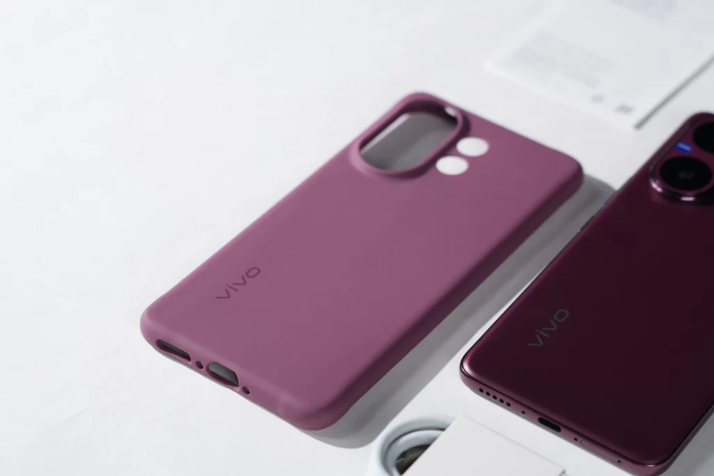 A shot of the purple protective case for the Vivo V60, showing the cutouts for the camera and ports, positioned next to the phone itself.