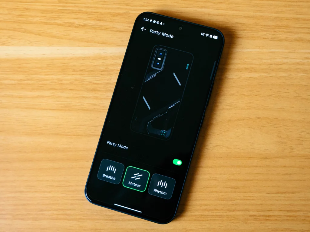 A close-up of the Infinix GT smartphone screen displaying a "Party Mode" setting in an app. The app allows the user to select lighting effects for the phone's back, with three options shown at the bottom: Breathe, Meteor, and Rhythm. A graphic of the phone's back is in the center.