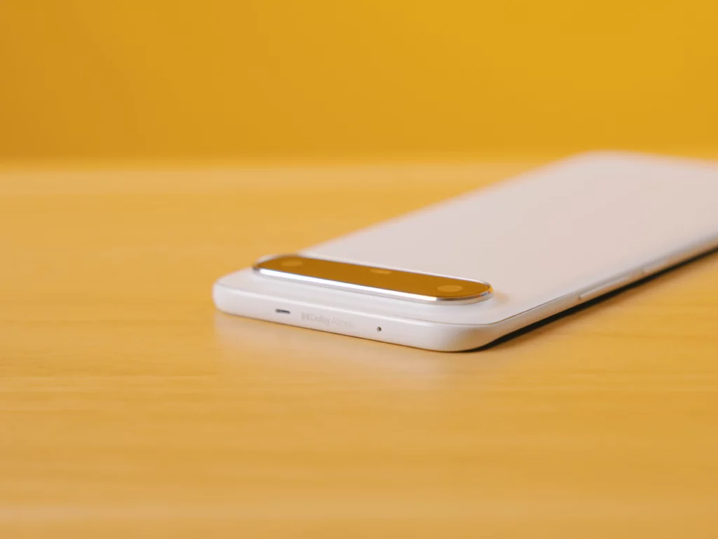 Close-up of the top edge of the white TECNO SPARK Slim phone, showing the Dolby Atmos logo printed near the camera module.