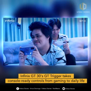 Two gamers sit on a couch in a blue-lit room, both playing on Infinix smartphones. The gamer in the foreground smiles while holding a dark-blue Infinix GT 30 phone horizontally, featuring a patterned back panel.