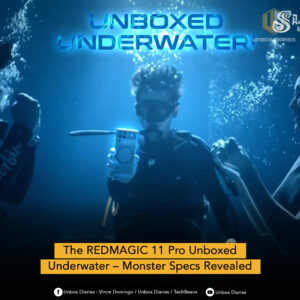 Three people are underwater in a dark blue, murky environment. The person in the center, wearing goggles and a snorkel, is holding up a smartphone, which is glowing faintly. Bubbles are visible around them. Large, glowing blue text at the top reads "UNBOXED UNDERWATER". The "UNBOX DIARIES" logo is at the top right. A yellow banner at the bottom states "The REDMAGIC 11 Pro Unboxed Underwater – Monster Specs Revealed". Social media icons and text are present at the very bottom.