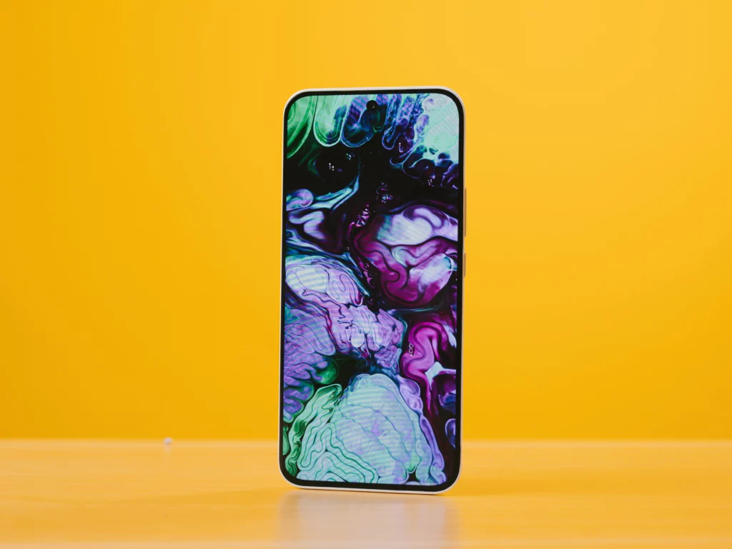 The front of the TECNO SPARK Slim smartphone on a yellow background, displaying a swirling blue, purple, and green abstract wallpaper.