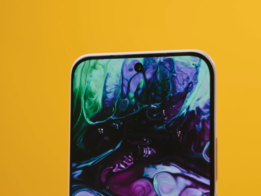 Extreme close-up of the top edge of the TECNO SPARK Slim screen, showing the minimal bezel, punch-hole selfie camera, and vibrant wallpaper.