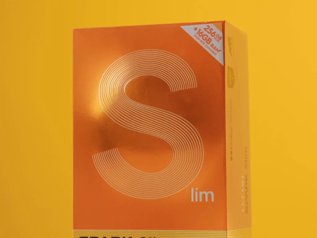 Close-up of the orange retail box for the TECNO SPARK Slim phone, highlighting the large 'S' graphic and the 256GB + 16GB RAM specification.