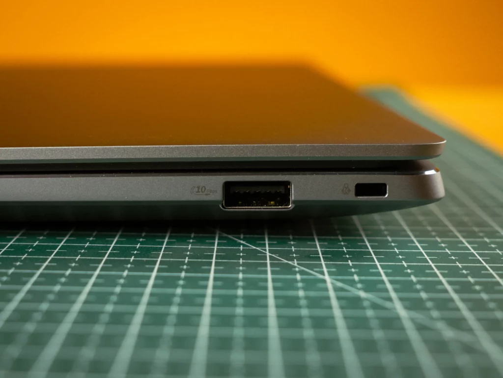 A close-up of the right side ports of the ASUS ExpertBook. From left to right: a USB-A 3.2 port (marked '10 Gbps') and a small security lock slot, possibly a Kensington lock slot.