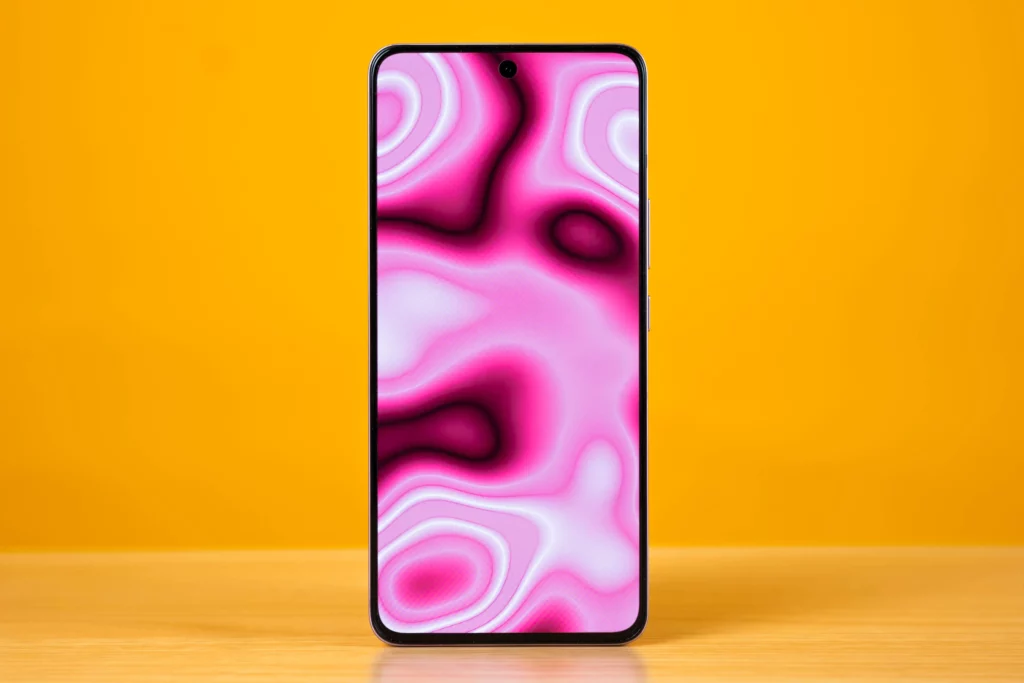 A full frontal view of the vivo V60 Lite smartphone's display, which shows a vibrant, swirling pink and purple abstract wallpaper. The screen has thin bezels and a center punch-hole cutout for the front camera at the top.