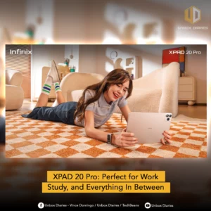 A smiling woman is lying on an orange and white checkered rug indoors, propped up on her stomach, looking down at and holding the Infinix XPAD 20 Pro tablet in a relaxed home setting.