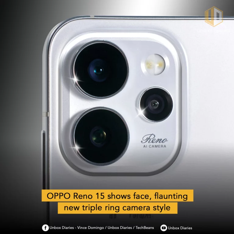 A close-up of the back of a silver smartphone, likely the OPPO Reno 15, is featured, highlighting its camera module. The module has a distinctive design with three circular lenses of varying sizes, arranged in a triangular pattern, and a flash. The text "Reno AI CAMERA" is visible within the module. The background is a blurred silver surface of the phone. The "UNBOX DIARIES" logo is at the top right. A yellow banner at the bottom reads "OPPO Reno 15 shows face, flaunting new triple ring camera style". Social media icons and text are present at the very bottom.