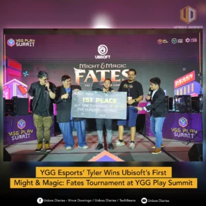 "Five individuals pose on a brightly lit stage under the Ubisoft logo. The center individual, Tyler, holds a giant check for $1,500, signifying his victory at the Might & Magic: Fates Invitational at the YGG Play Summit. A caption at the bottom reads, 'YGG Esports’ Tyler Wins Ubisoft’s First Might & Magic: Fates Tournament at YGG Play Summit'."