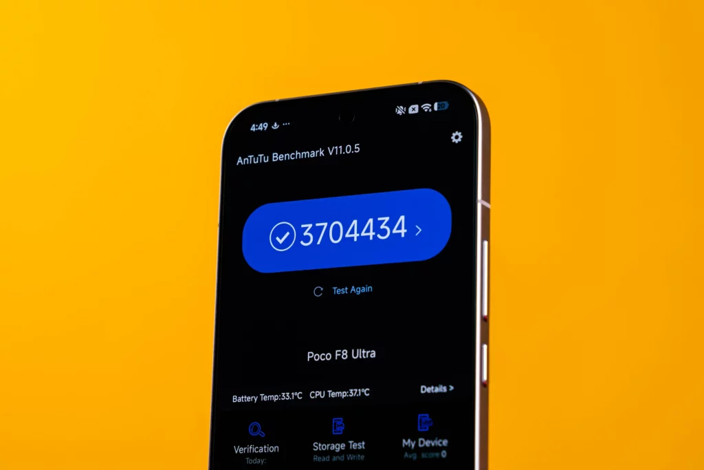 A close-up of the POCO F8 Ultra running the AnTuTu Benchmark V11.0.5, showing a final score of 3,704,434 with a checkmark, as well as battery and CPU temperature readings.