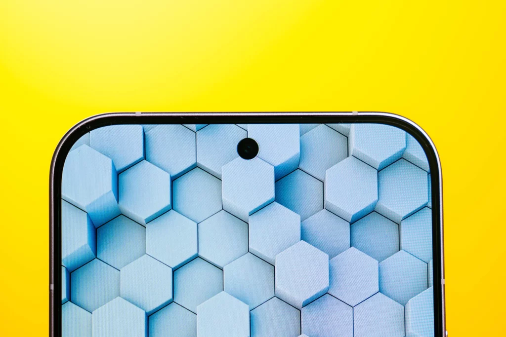 A close-up of the top edge of the POCO F8 Ultra screen, showing the center punch-hole front camera cutout. The wallpaper features a repeating pattern of light blue and white 3D hexagonal shapes.