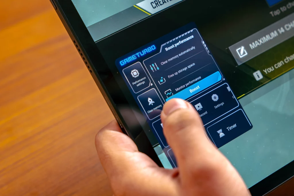 Close-up shot of a hand tapping the "Boost" button within the "Game Turbo" feature on the POCO Pad M1, which offers options like clearing memory and monitoring performance.