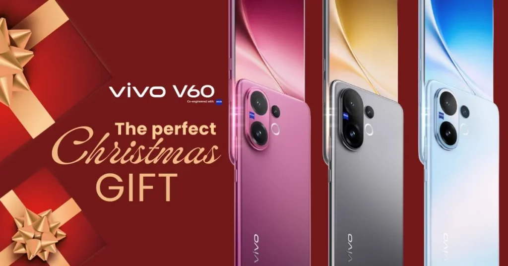 A promotional banner for the vivo V60 featuring the text "The perfect Christmas GIFT" in elegant gold and white lettering. The background is festive red with gold-ribboned presents. Three vivo V60 phones are displayed in a row, showing the available colors: pink, grey, and light blue.