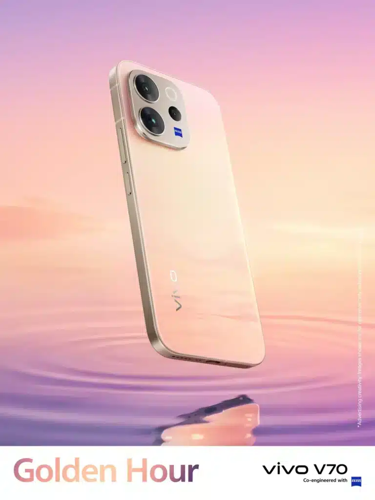 A professional product shot of the vivo V70 5G in Golden Hour, featuring a warm pink-to-gold gradient finish. The phone is shown floating above a soft purple water-ripple background, highlighting its sleek design and ZEISS branded camera module.