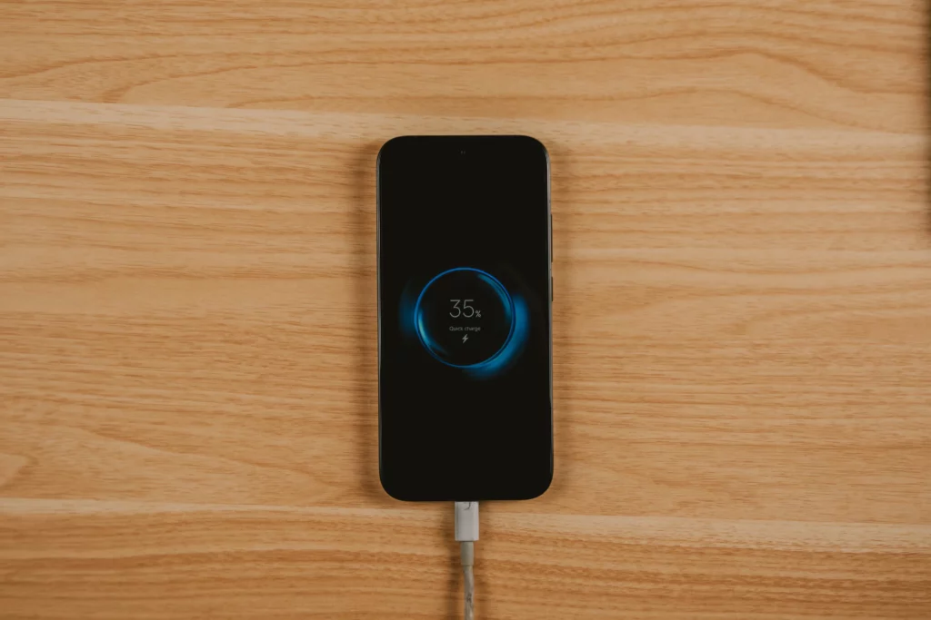 The POCO X8 Pro Iron Man Edition placed in a wooden surface with the screen showing the quick charge animation at 35%.