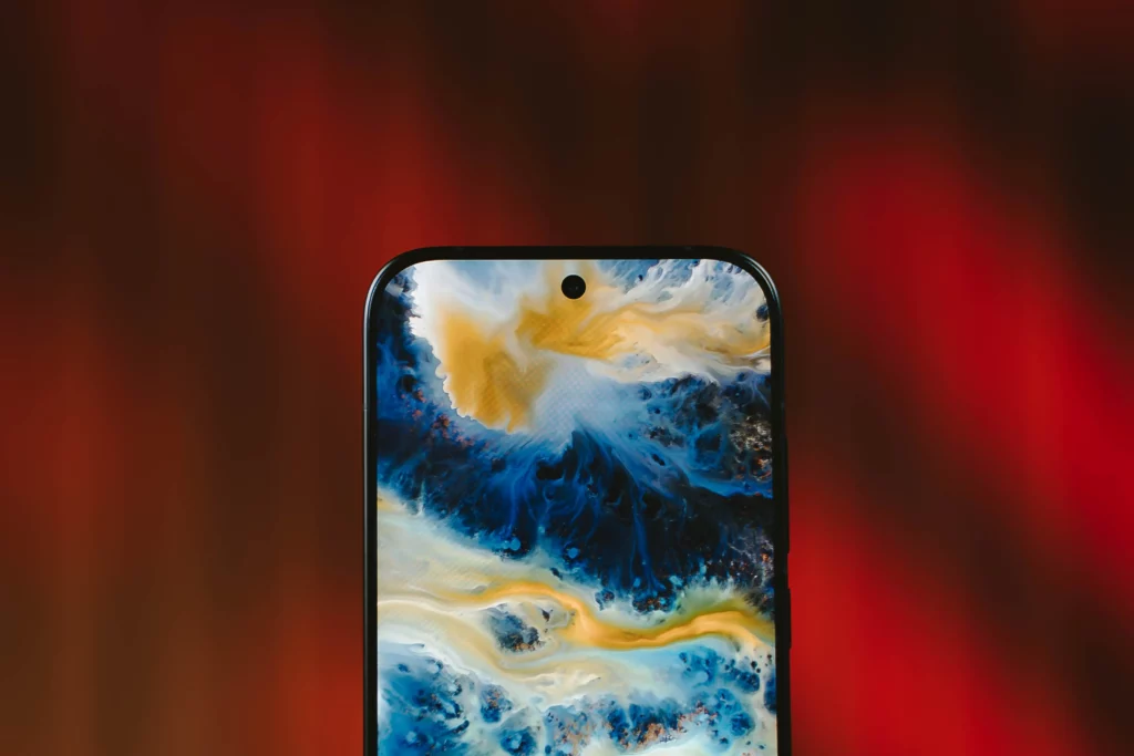 A close-up of the POCO X8 Pro Iron Man Edition's punch-hole camera with the screen showing a yellow, white, and blue abstract image.