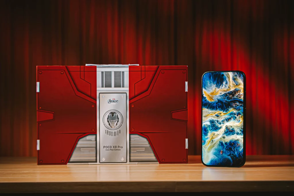 The POCO X8 Pro Iron Man Edition standing atop a wooden surface besides its box