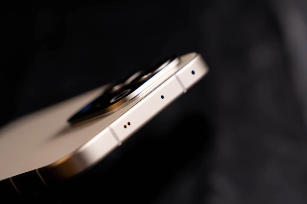 Close-up profile view of the top edge of the vivo V70 5G in a champagne gold finish. The image highlights the flat metallic frame, antenna lines, and secondary microphone holes.