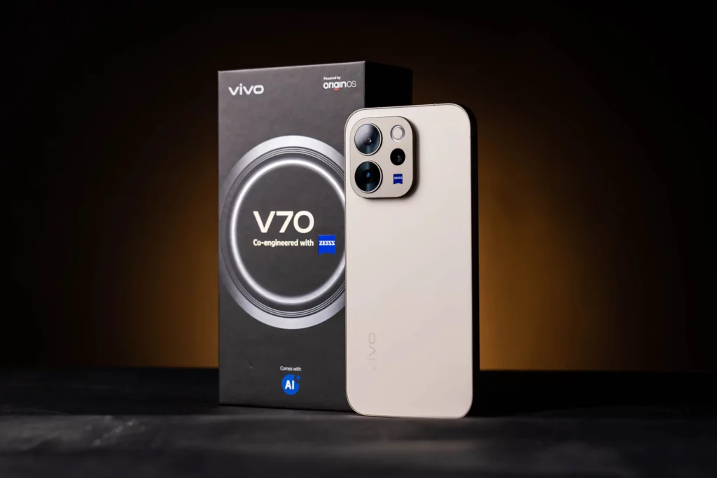 A studio shot of the back of the vivo V70 5G in a light gold color, standing next to its retail box. The large square camera module features ZEISS branding and multiple lenses.