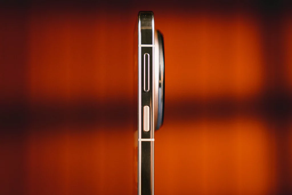 A close-up of the right edge of the device, showing the metallic frame, a long volume rocker, and a textured power button.