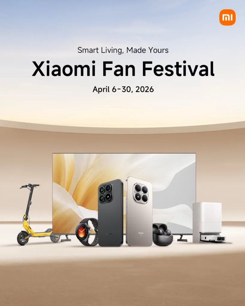 A clean promotional graphic for the Xiaomi Fan Festival 2026, running from April 6–30, 2026, with the slogan "Smart Living, Made Yours." The official orange Xiaomi logo is in the top-right corner. The image showcases a lifestyle tech lineup: a large TV with an abstract gold wallpaper, a black Xiaomi flagship phone, a silver Redmi phone, a smartwatch, black earbuds, a yellow electric scooter, and a white robot vacuum cleaner. The background is a minimalist, warm-toned indoor setting with soft lighting.