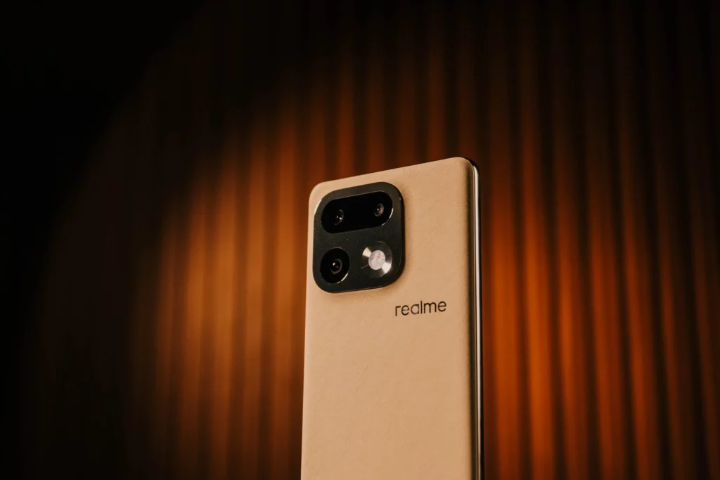 A close-up low-angle shot of the realme 16 Pro+ 5G in the Master Gold colorway.