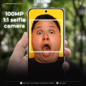 A promotional graphic from "Unbox Diaries" featuring a person making a shocked expression on a smartphone screen. Large text on the left reads "100MP 1:1 selfie camera," with a glowing white square overlaying the center of the person's face.