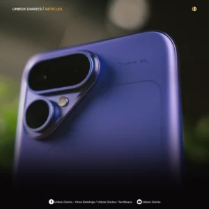 A square, high-quality close-up photograph of a purple smartphone's upper back. The phone has a smooth, matte finish with a prominent, raised pill-shaped camera module housing two lenses, alongside an additional circular lens and flash unit. Small text near the camera reads "CURVE 5G". The top left reads "UNBOX DIARIES / ARTICLES". The bottom features a black gradient overlay with white icons and text for Facebook and YouTube crediting Unbox Diaries, Vince Domingo, and TechBeans.
