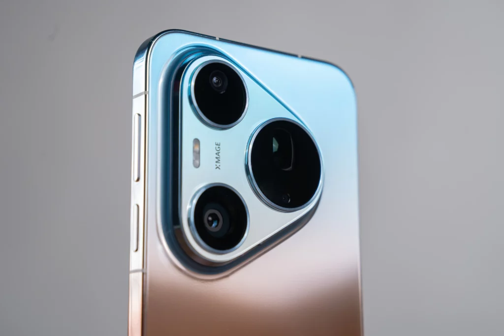 Close-up of a smartphone's rear camera module with a triangular housing holding three lenses and an XMAGE label.