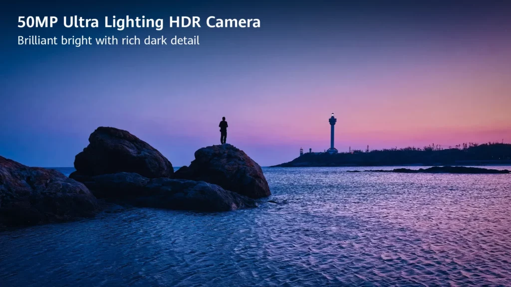 Silhouette of a person standing on coastal rocks facing a lighthouse against a purple dusk sky, highlighting the 50MP Ultra Lighting HDR Camera feature.