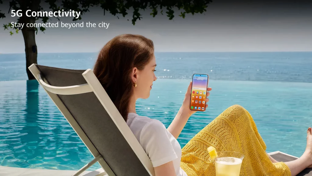 A woman relaxing on a lounge chair by an infinity pool overlooking the ocean, holding a smartphone showing app icons on screen. Text overlay reads: "5G Connectivity. Stay connected beyond the city."