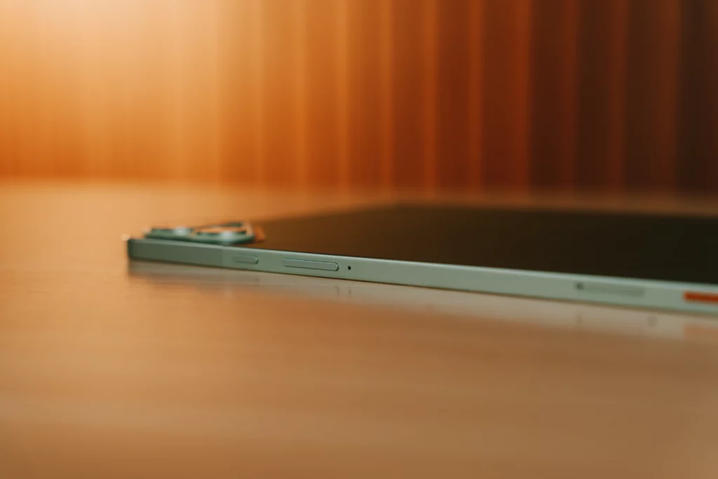 Side profile of the TECNO MEGAPAD 2 showing its slim metallic edge, volume buttons, and microphone hole.